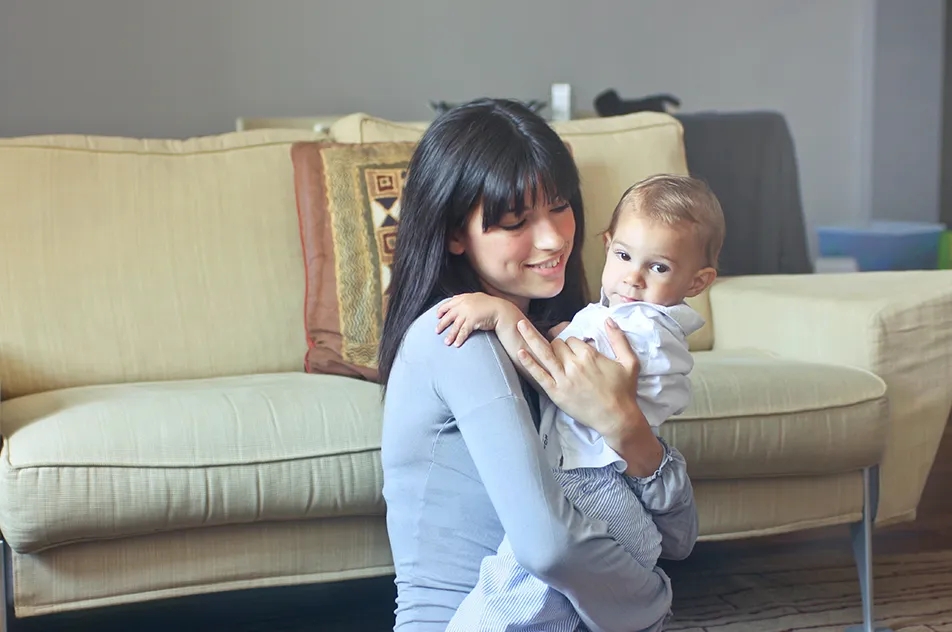 mummy in gray sweater carrying toddler