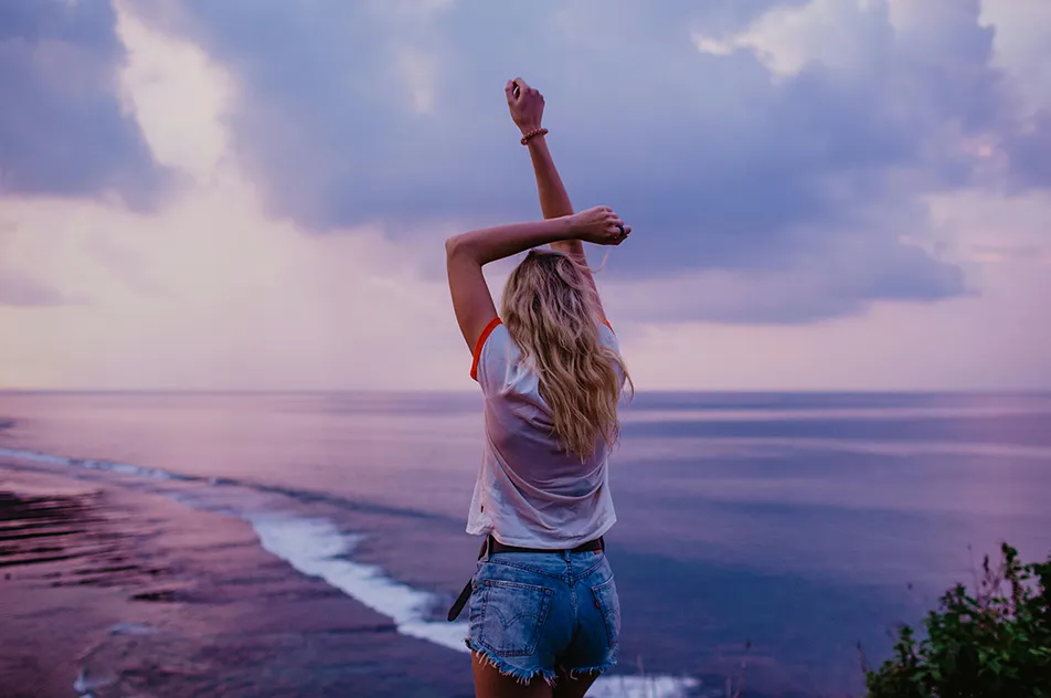 slim woman enjoying endless seascape on beach