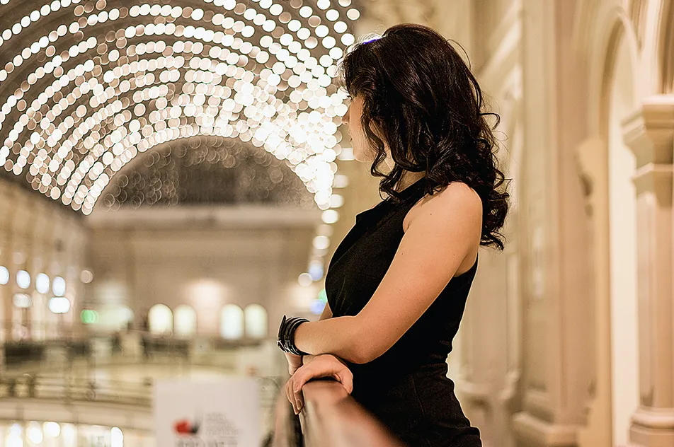 standing woman wearing black sleeveless dress